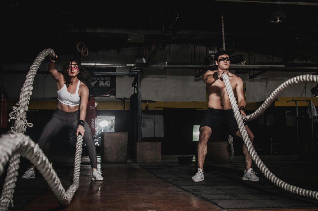 How to Create a Budget-Friendly Home Gym: Your Ultimate Guide 2 Two people engage in a powerful indoor battle rope workout, showcasing strength and energy.