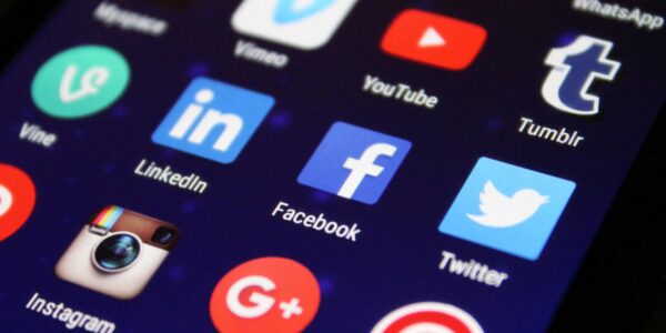 Close-up of a smartphone screen showing various social media app icons such as Facebook and Twitter.