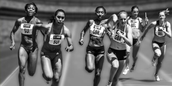 Female athletes in a high-stakes track race showcasing physical prowess and competition.
