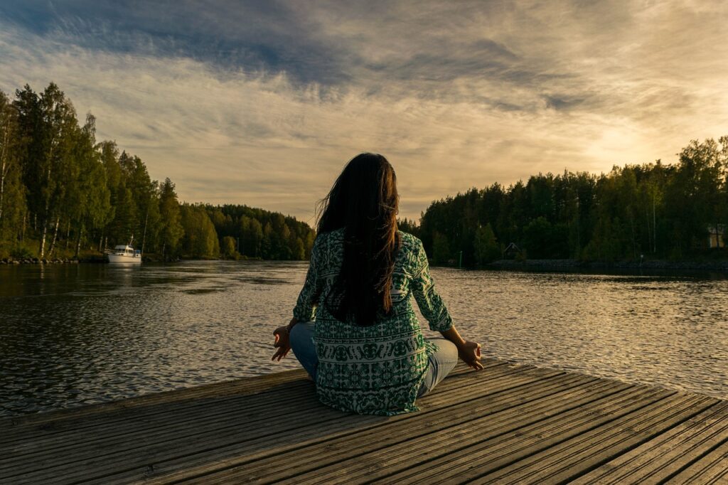The Key to True Wellness, A Holistic Path to Living Well, yoga, woman, lake, nature, outdoors, lotus pose, meditation, mindfulness, balance, meditating, wellness, sunset, twilight